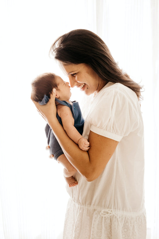 Beautiful mother with new baby, smiling and laughing with each other.