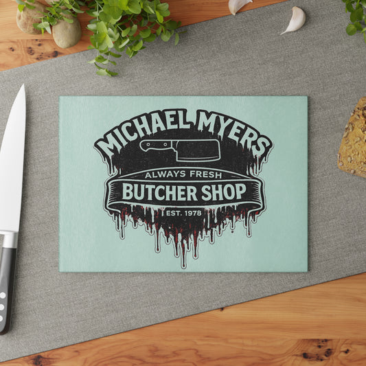 Bring a chilling touch of horror-inspired style to your kitchen with the Michael Myers Butcher Shop Glass Cutting Board. Designed for fans of classic slasher movies and spooky kitchen décor, this bold cutting board combines everyday functionality with a dark, Halloween-inspired aesthetic.