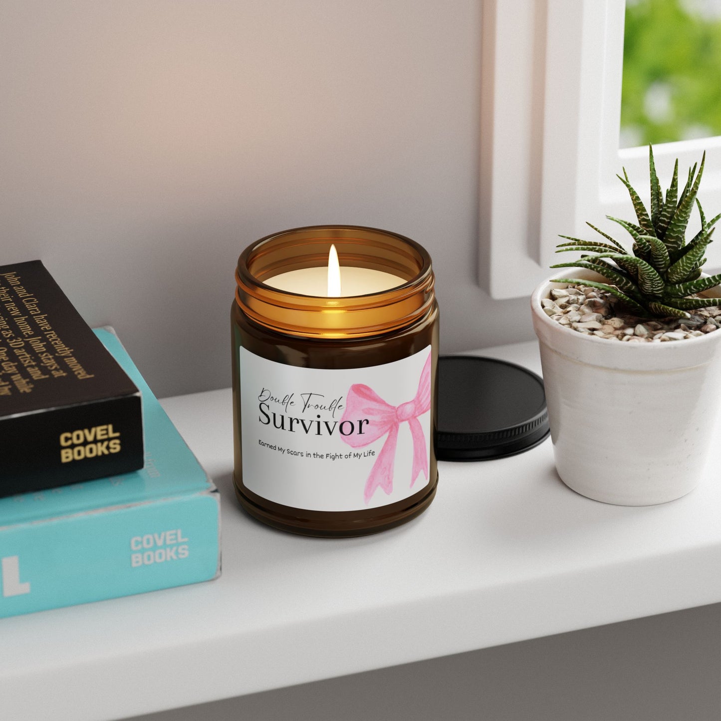 Candle in an amber jar with a 'Survivor' label on a shelf with books and a plant.