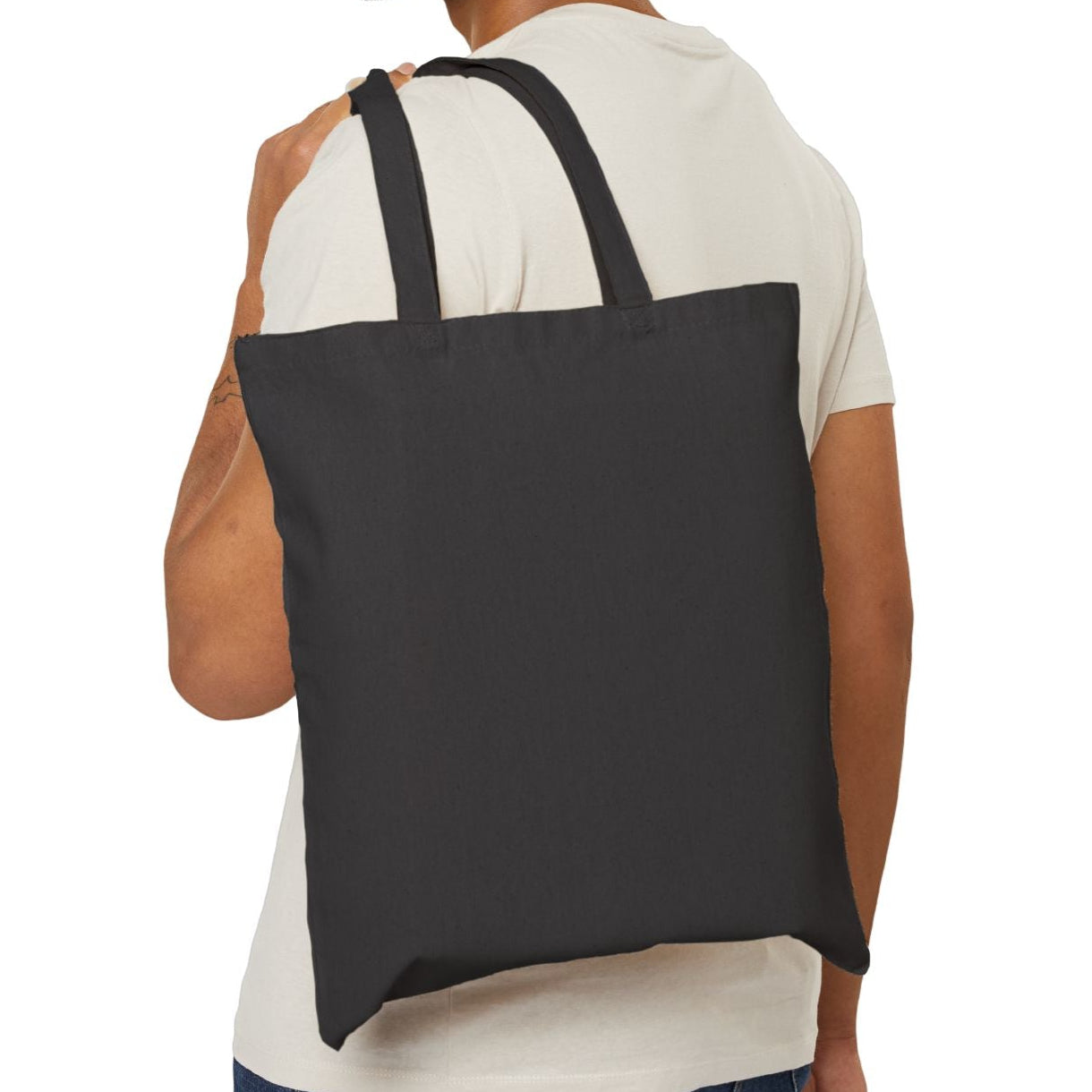 Man carrying a black tote bag on a white background