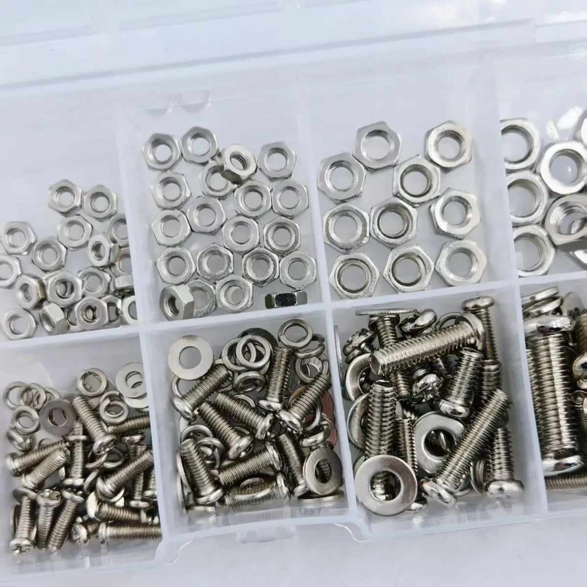 Assorted metal nuts and screws in a clear plastic organizer.