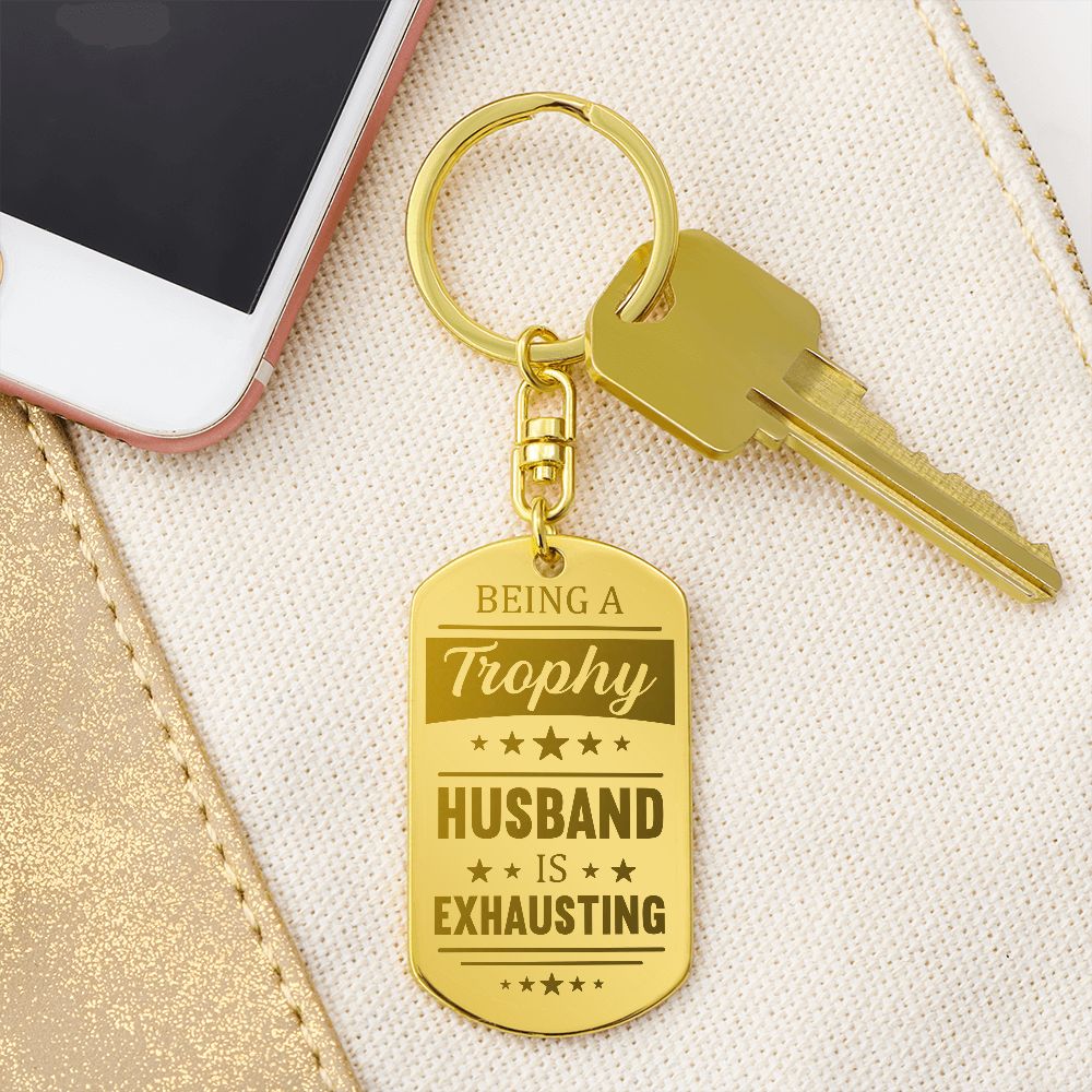 Being a trophy husband is exhausting  Create a unique keepsake with our Engraved Dog Tag Keychain. This high-quality stainless steel piece can be customized on the back in a scripted font, with 2 lines of text, up to 20 characters each.