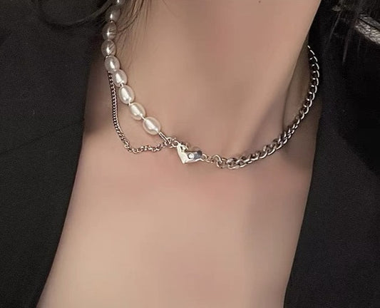 This chic Pearl & Metal Chain Heart Choker is crafted from a combination of metal and pearl chains that provide a luxuriously sophisticated look. The heart-shaped pendant adds a stylish, eye-catching detail that makes this piece a must-have accessory. Its adjustable chain ensures a comfortable, snug fit.