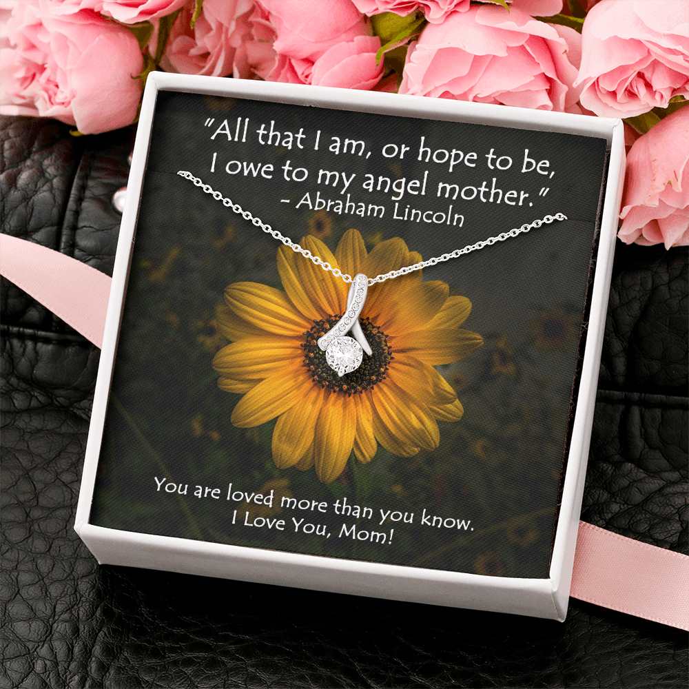 The petite ribbon shaped pendant is finished with 14K white gold over stainless steel, and is embellished with dainty clear crystals surrounded by a sparkling 7mm round cut Cubic Zirconia.