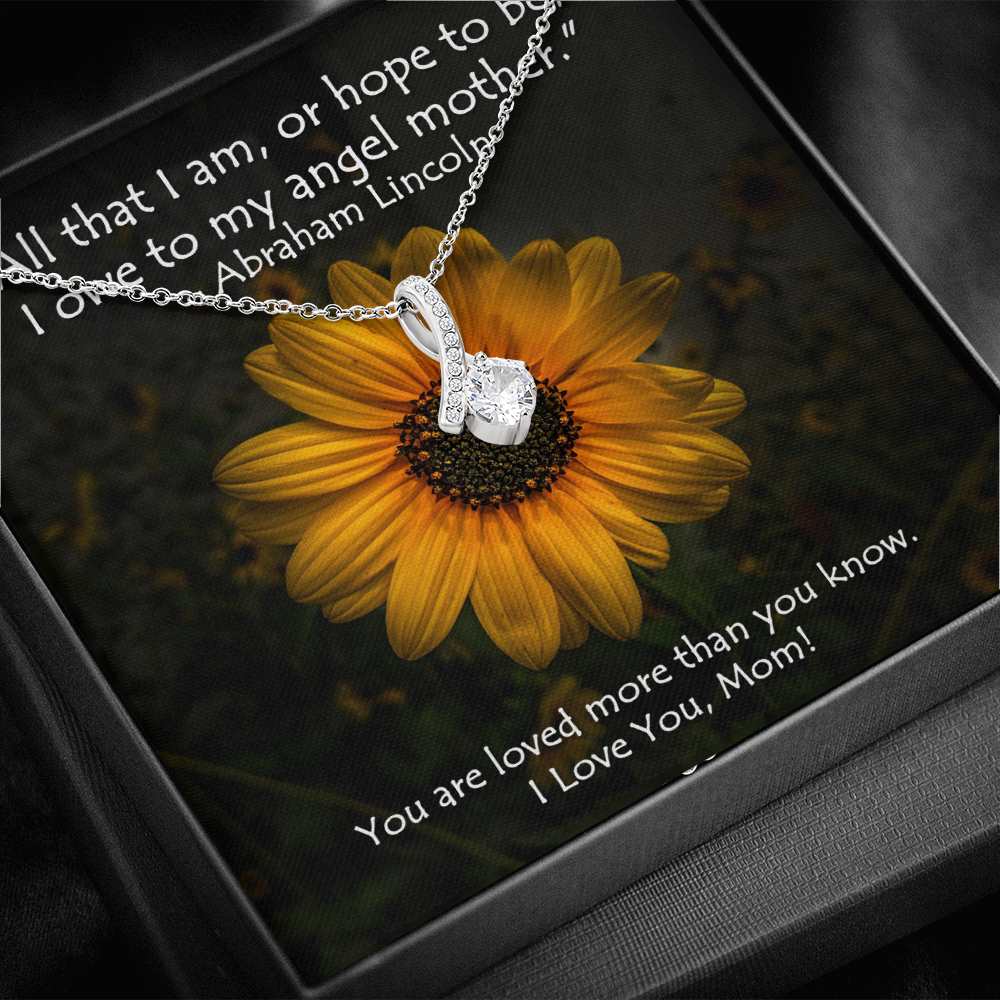 The petite ribbon shaped pendant is finished with 14K white gold over stainless steel, and is embellished with dainty clear crystals surrounded by a sparkling 7mm round cut Cubic Zirconia.