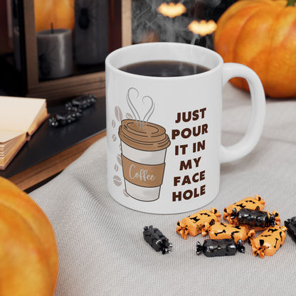 White mug with coffee design and text, surrounded by Halloween-themed treats on a table.