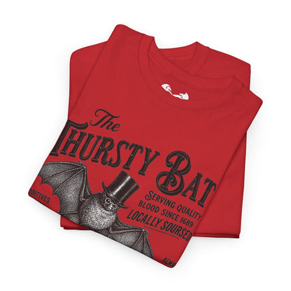 A folded red t-shirt with a vintage-style black graphic of a bat wearing a top hat and the text 'The Thirsty Bat' on a clean white background.