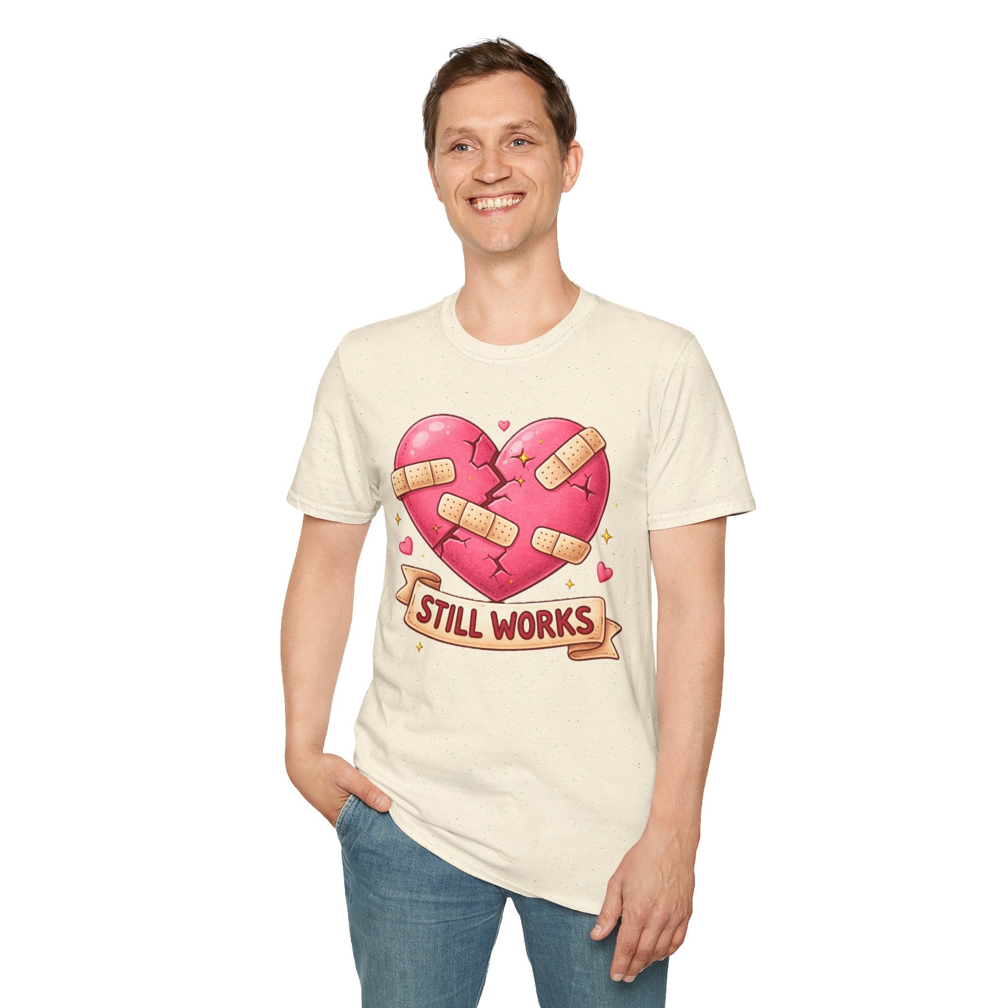 Person wearing a cream t-shirt with a heart graphic and 'Still Works' text on a white background