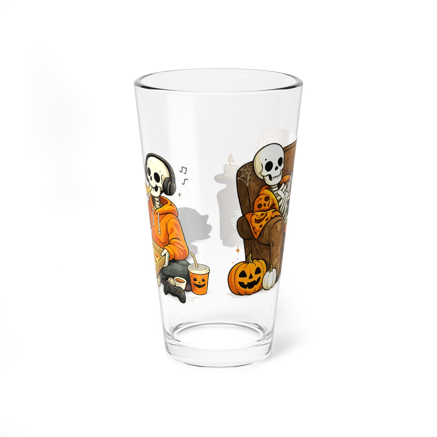 A clear pint glass featuring a cartoon Halloween illustration of two skeleton characters, one smoking a pipe and the other lounging on a couch with a pumpkin, shown on a white background.