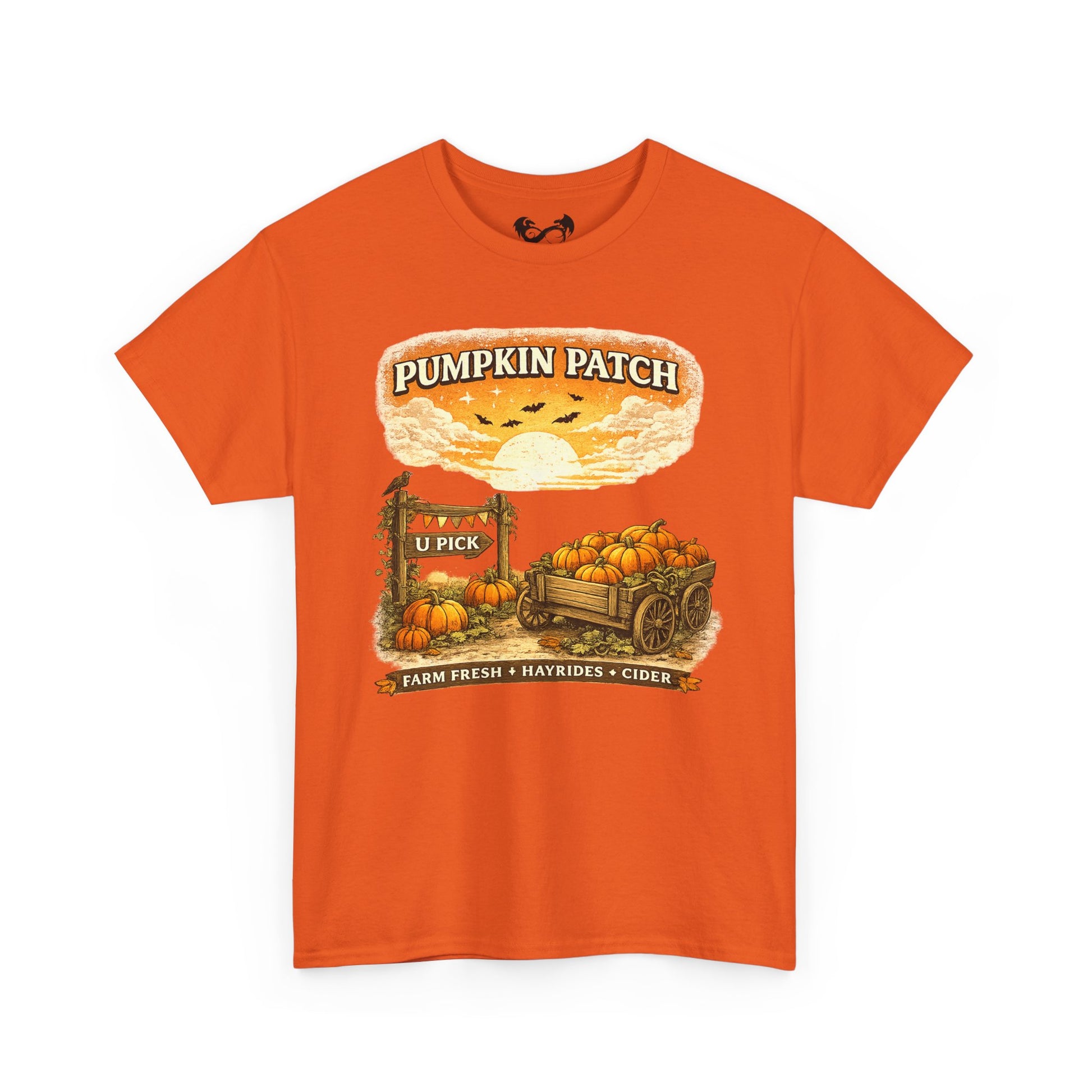 An orange short-sleeve crewneck t-shirt featuring a vintage-style autumn graphic on the front with pumpkins, a wagon, a sign reading 'Pumpkin Patch', and the text 'Farm Fresh + Naturals + Cider'.