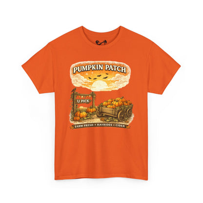 An orange short-sleeve crewneck t-shirt featuring a vintage-style autumn graphic on the front with pumpkins, a wagon, a sign reading 'Pumpkin Patch', and the text 'Farm Fresh + Naturals + Cider'.