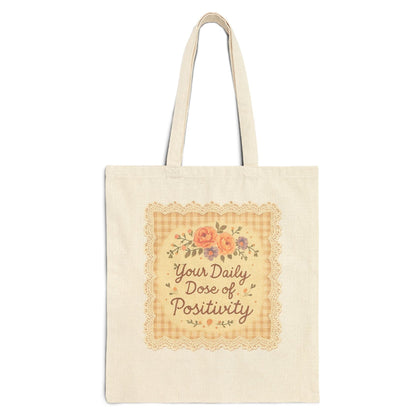 Tote bag with 'Your Daily Dose of Positivity' text and floral design on a white background