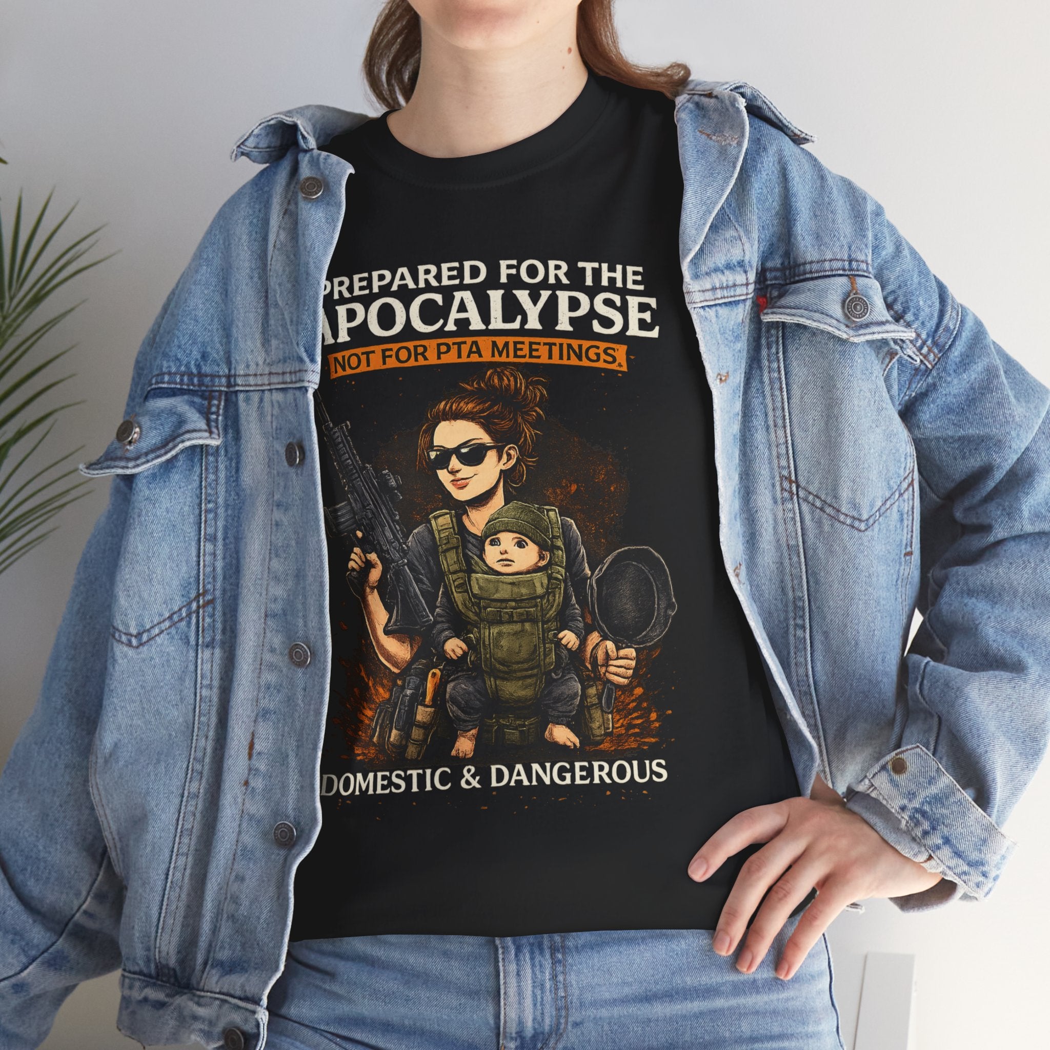 Person wearing a black t-shirt with graphic design and text, paired with a denim jacket.