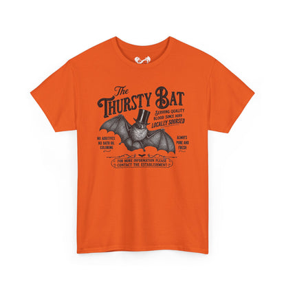 An orange short-sleeve crewneck t-shirt featuring a vintage-style graphic of a bat wearing a top hat with the text 'The Thirsty Bat' and additional decorative text around it, displayed on a clean white background.