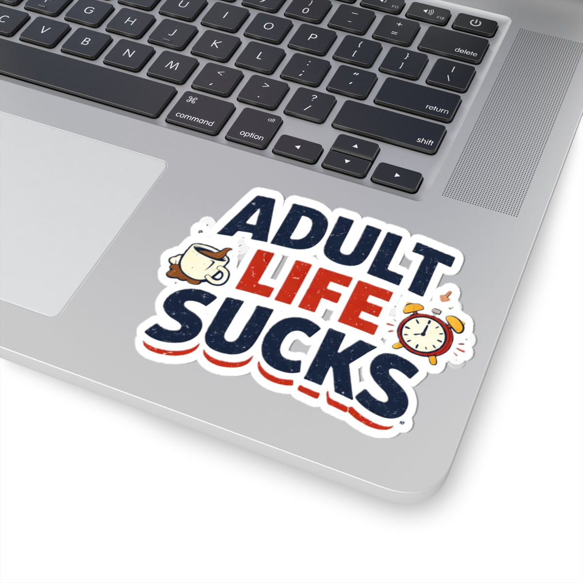 Laptop with a 'Adult Life Sucks' sticker on the palm rest area