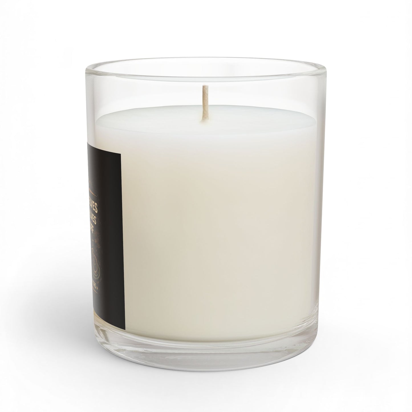 White candle in a clear glass container with a black label on a white background