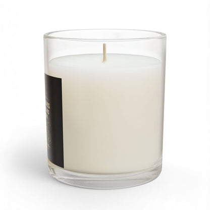 White candle in a clear glass container with a black label on a white background
