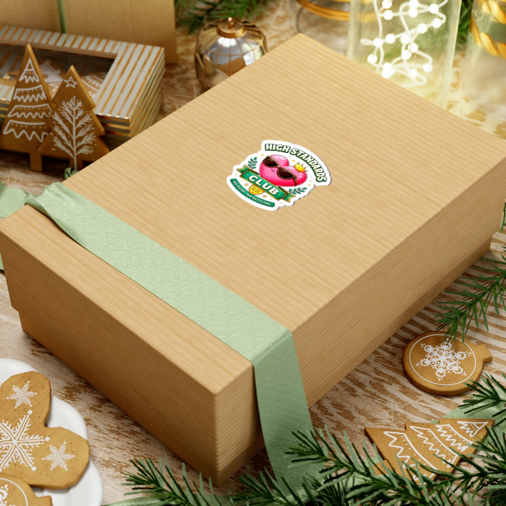 Gift box with a green ribbon and a logo on a festive background with cookies and decorations.