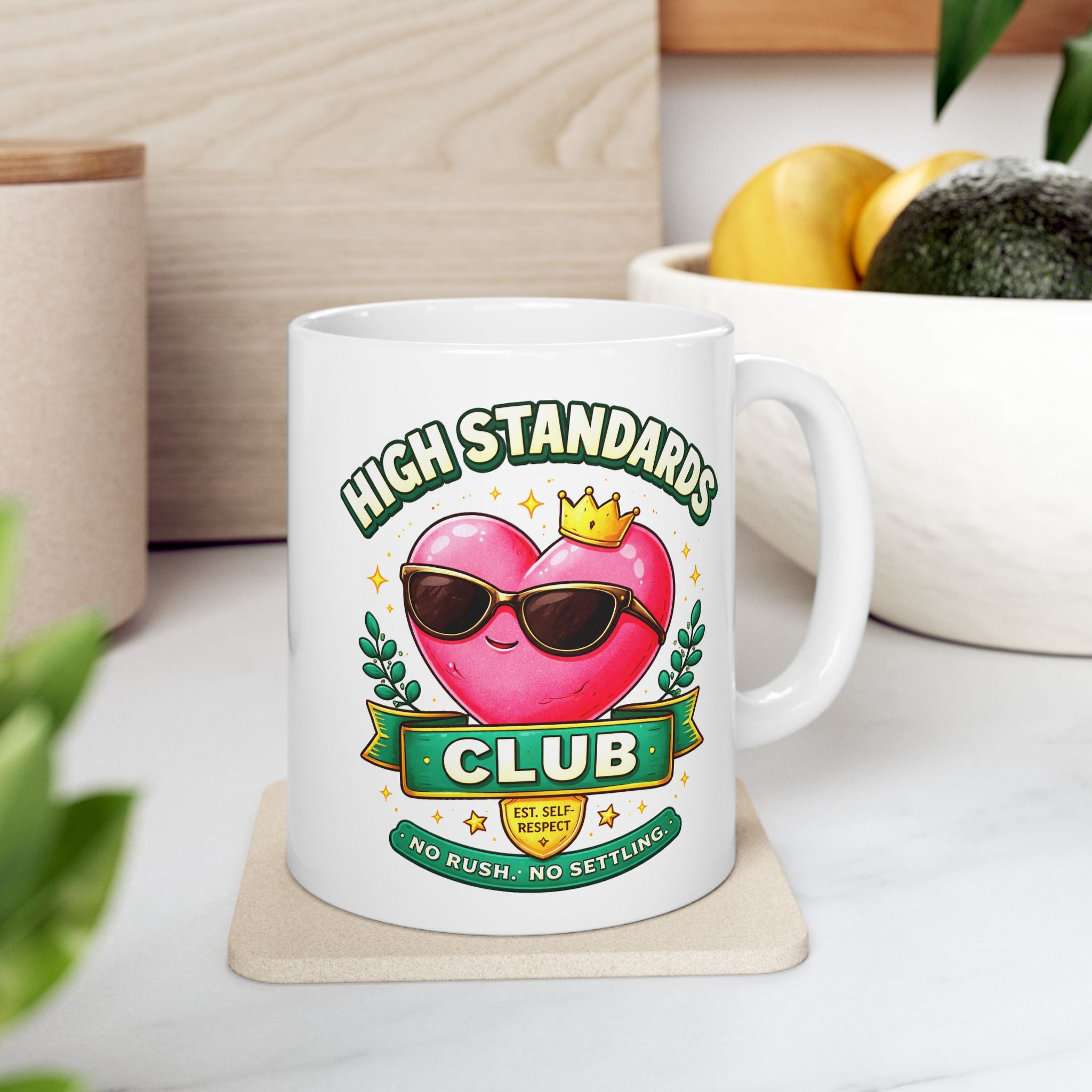 White mug with a heart design and 'High Standards Club' text on a light surface.
