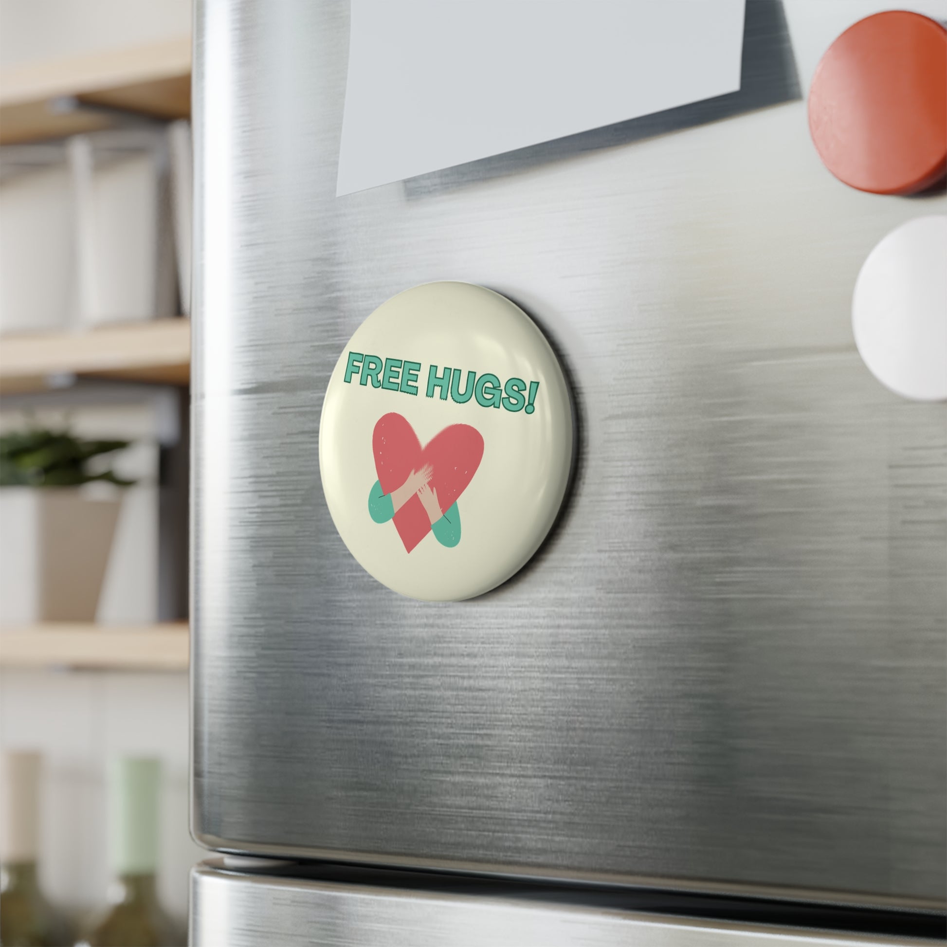 Fridge magnet with 'Free Hugs!' text and heart design on a metallic surface.