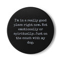 Black round coaster with white text on a white background