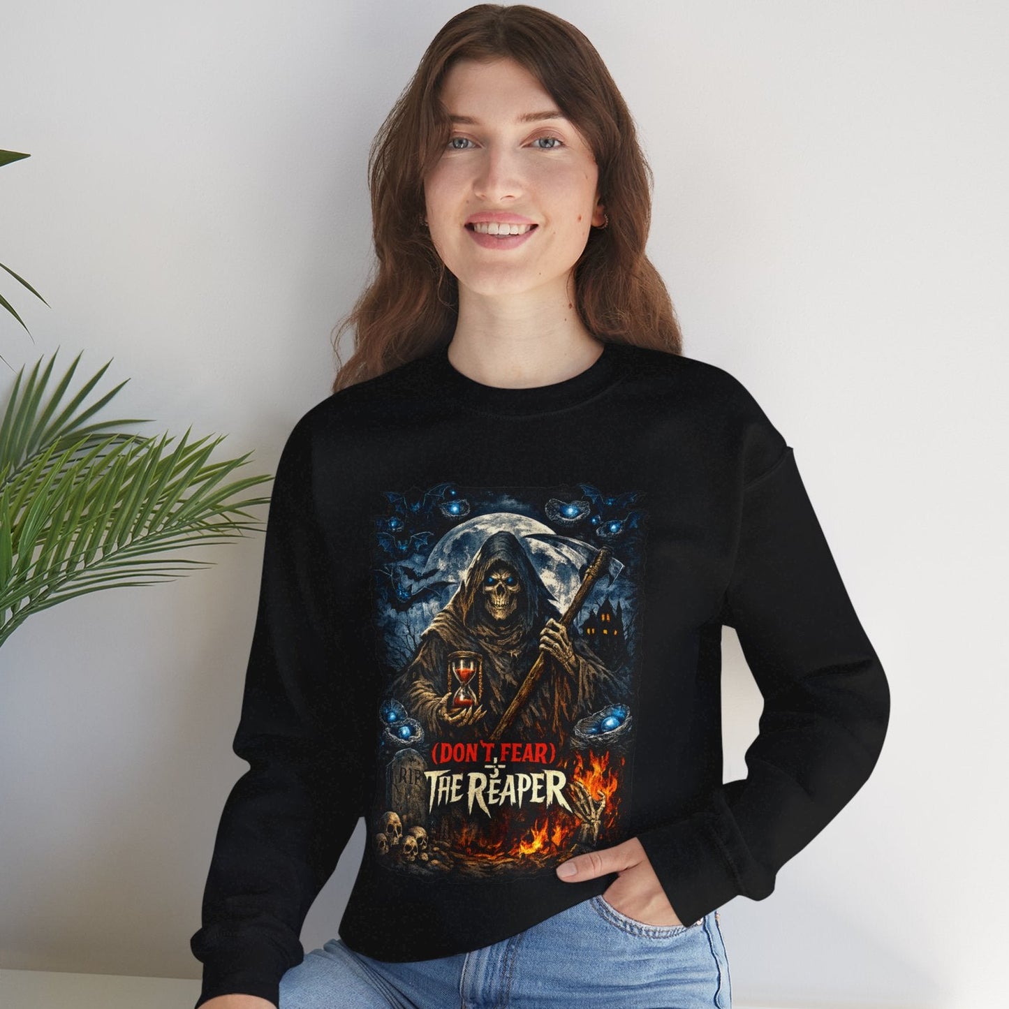 Person wearing a navy blue sweatshirt with 'Kare Kare' text and bowl graphic, sitting on a white surface with a plant in the background.