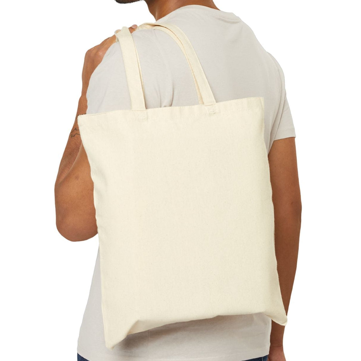 Man carrying a beige tote bag on a white background