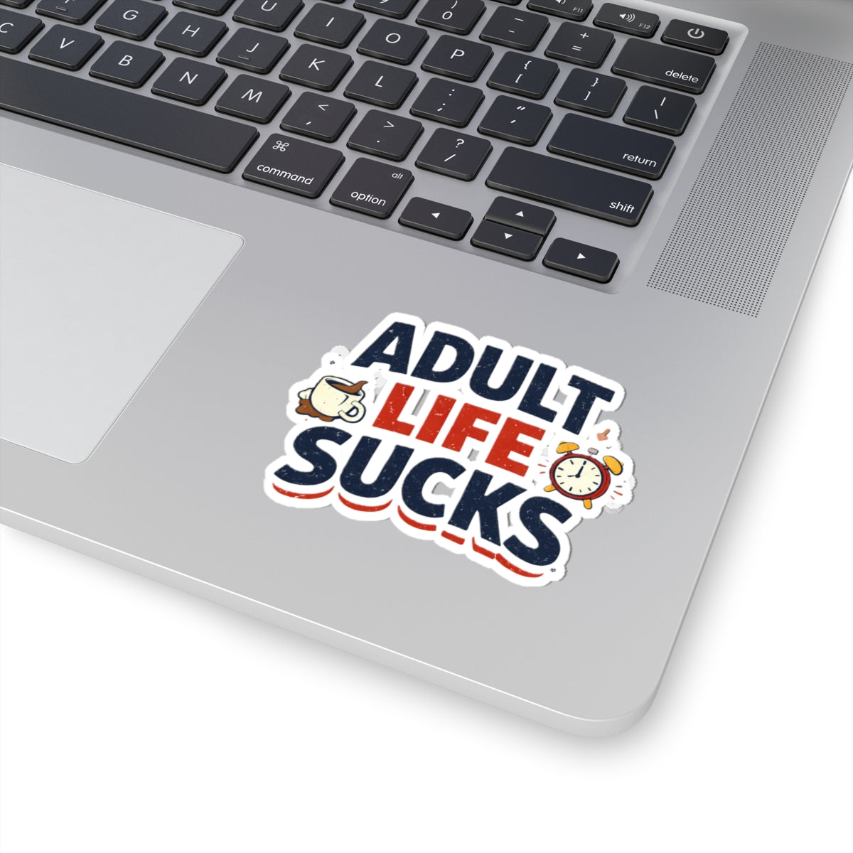 Laptop with a 'Adult Life Sucks' sticker on the palm rest area
