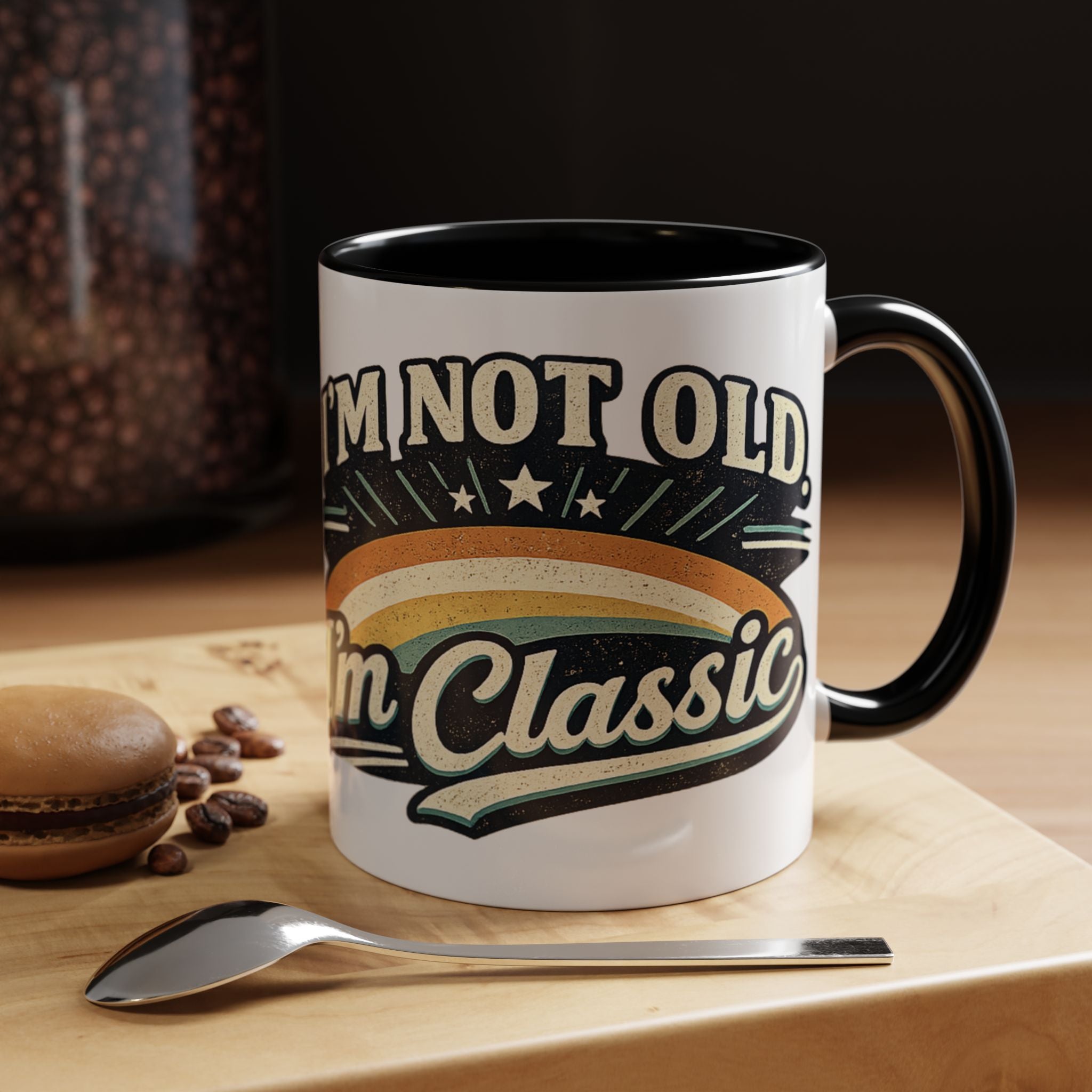 Mug with 'I'm not old, I'm classic' text on a wooden surface with coffee beans and a spoon.