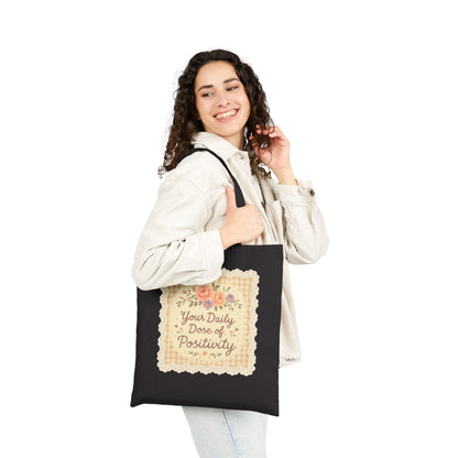 Woman holding a tote bag with text and floral design on a white background