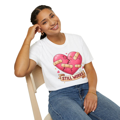 Person wearing a white t-shirt with a graphic of a heart and text, sitting on a chair.
