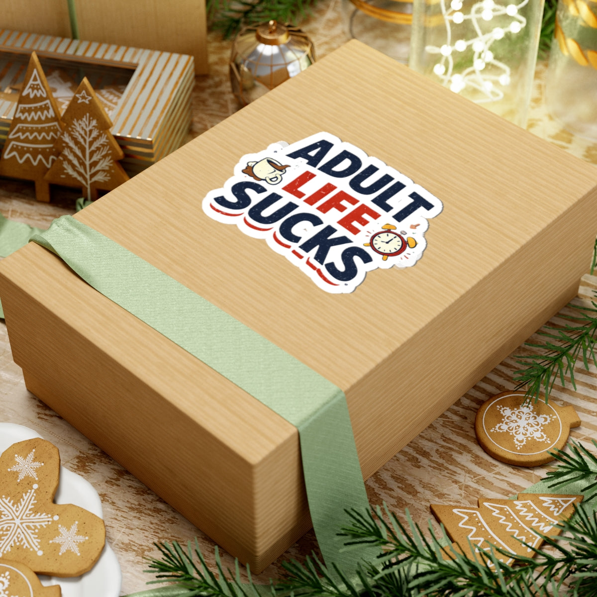 Wooden gift box with 'Adult Life Sucks' sticker on a festive background with cookies and decorations.