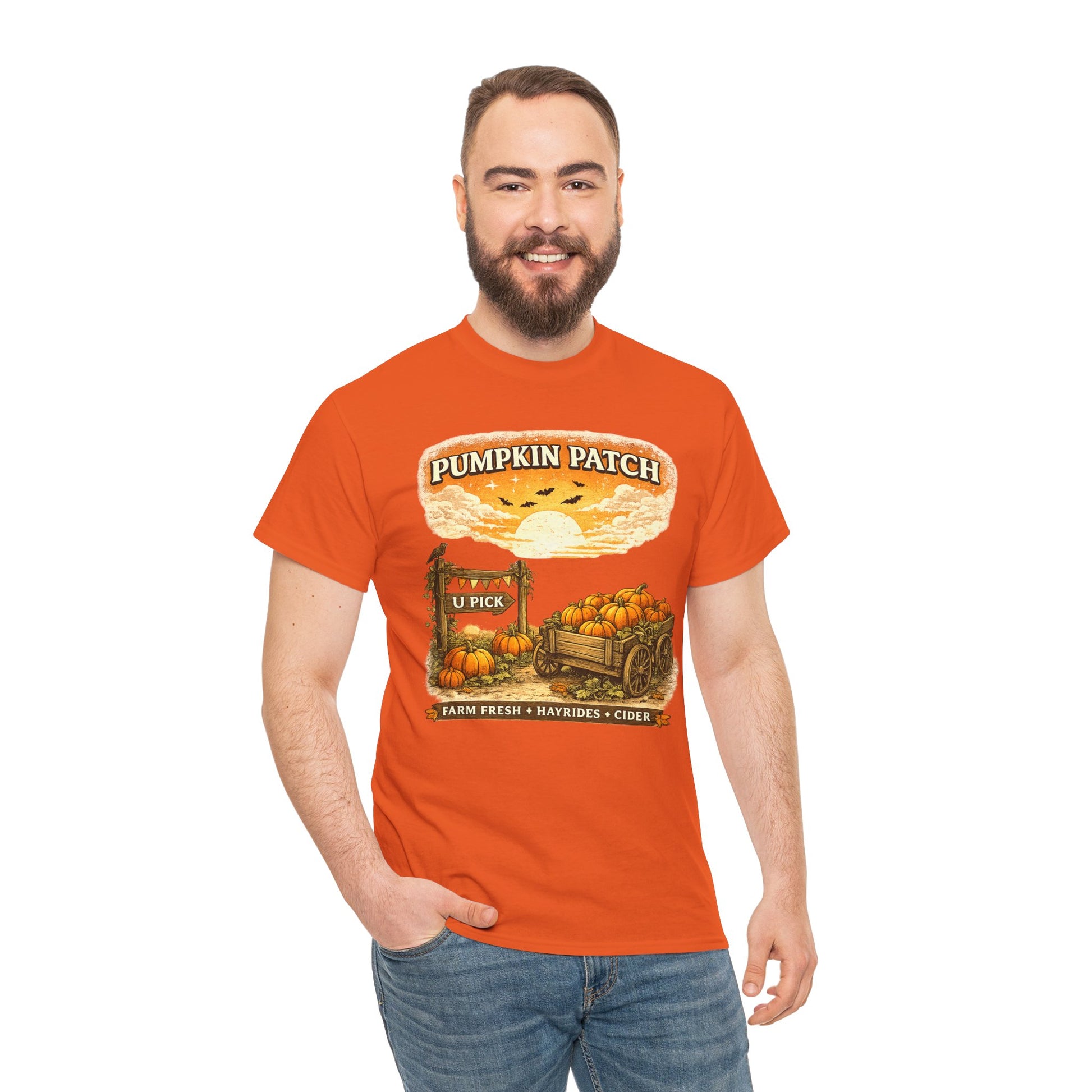 A man wearing a bright orange graphic t-shirt with a 'Pumpkin Patch' autumn harvest design, paired with blue jeans, against a plain white background.