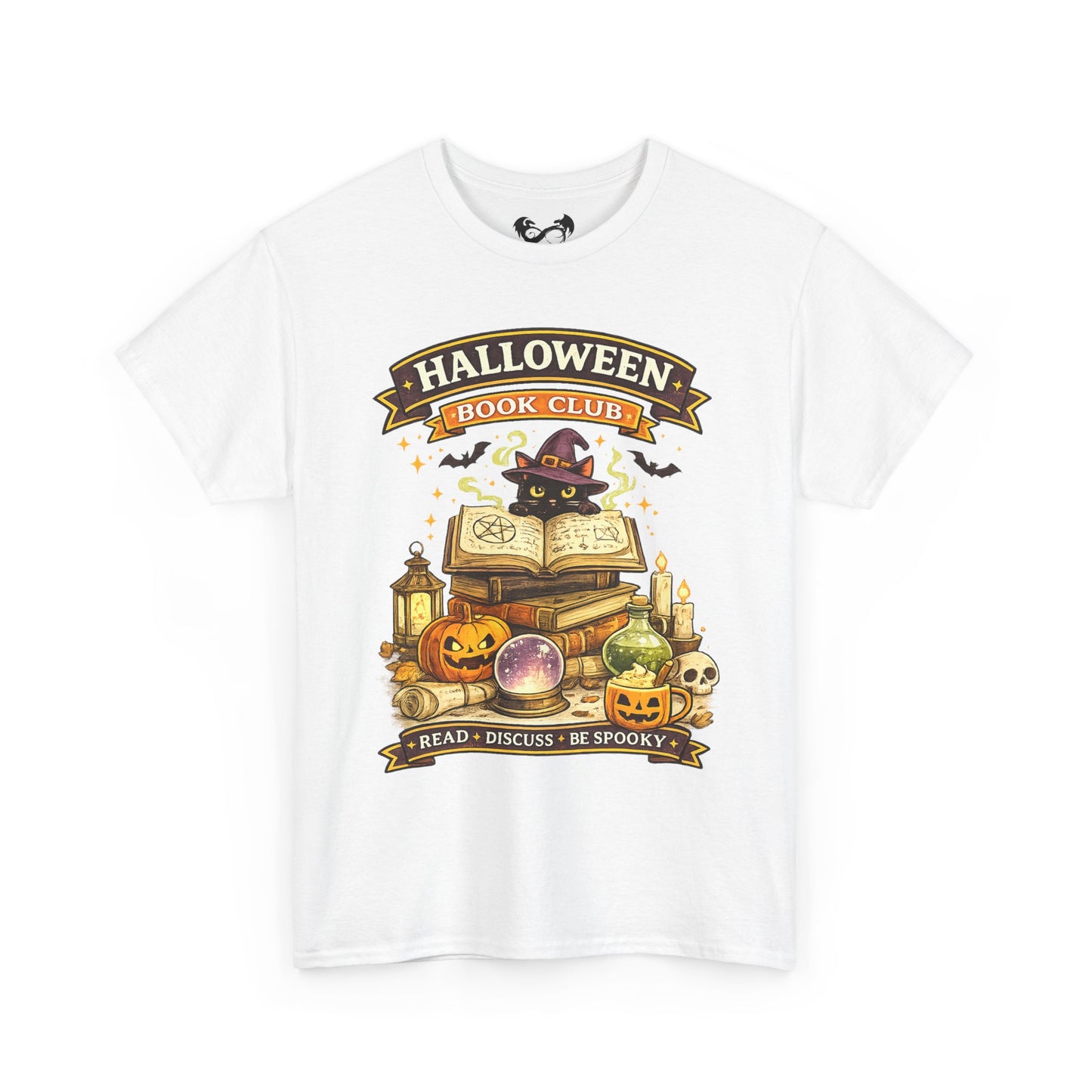 A white short-sleeve crewneck t-shirt featuring a colorful graphic print on the front. The graphic depicts a black cat dressed as a witch sitting on an open book, surrounded by pumpkins, candles, a lantern, and a crystal ball, with banners reading 'HALLOWEEN BOOK CLUB' and 'READ • DISCUSS • BE SPOOKY'.