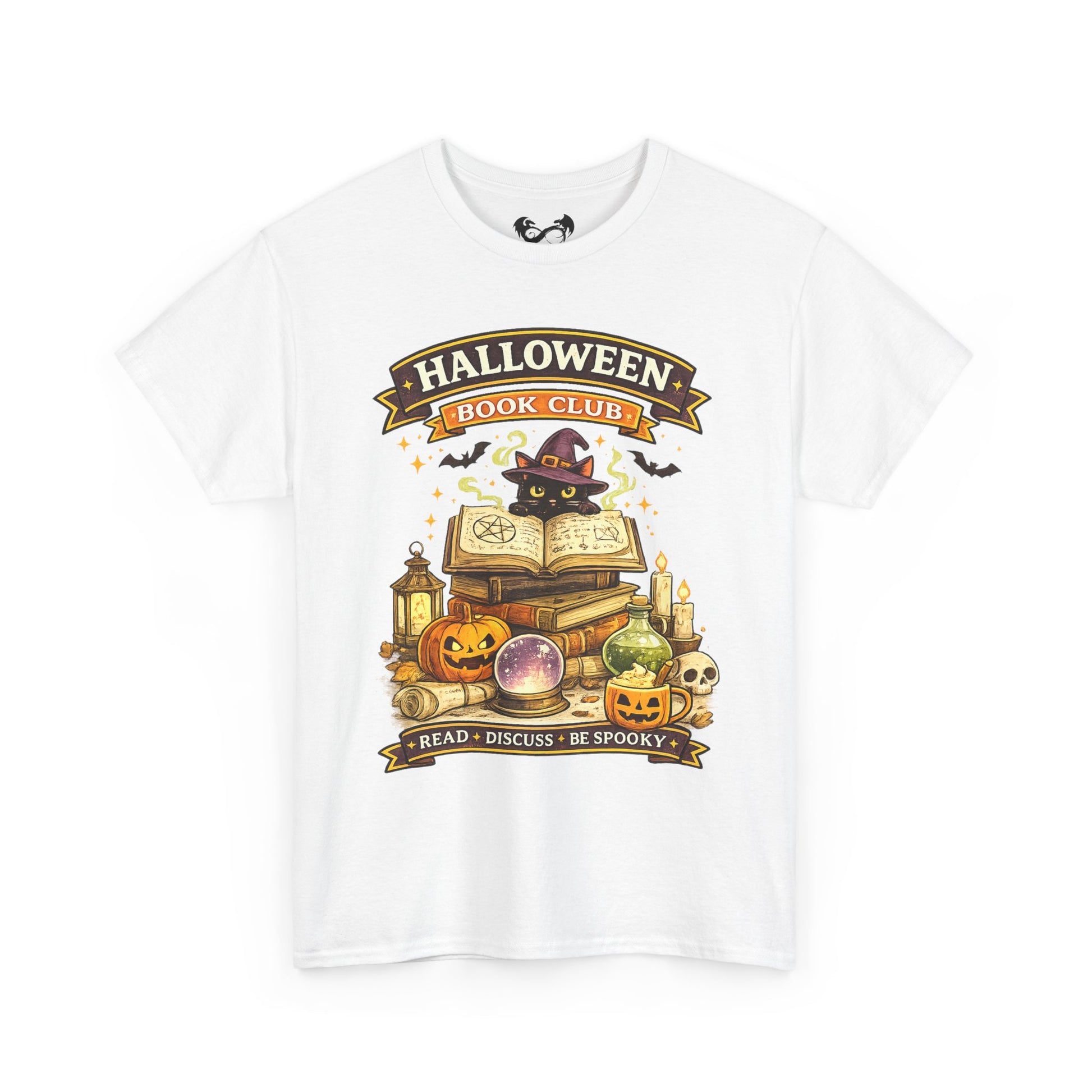 A white short-sleeve crewneck t-shirt featuring a colorful graphic print on the front. The graphic depicts a black cat dressed as a witch sitting on an open book, surrounded by pumpkins, candles, a lantern, and a crystal ball, with banners reading 'HALLOWEEN BOOK CLUB' and 'READ • DISCUSS • BE SPOOKY'.