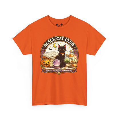 An orange short-sleeve crewneck t-shirt featuring a circular graphic print of a black cat, a pumpkin, a crystal ball, and potion bottles with the text 'BLACK CAT CLUB' and 'MAGIC * SPIRITS * FORTUNE'.