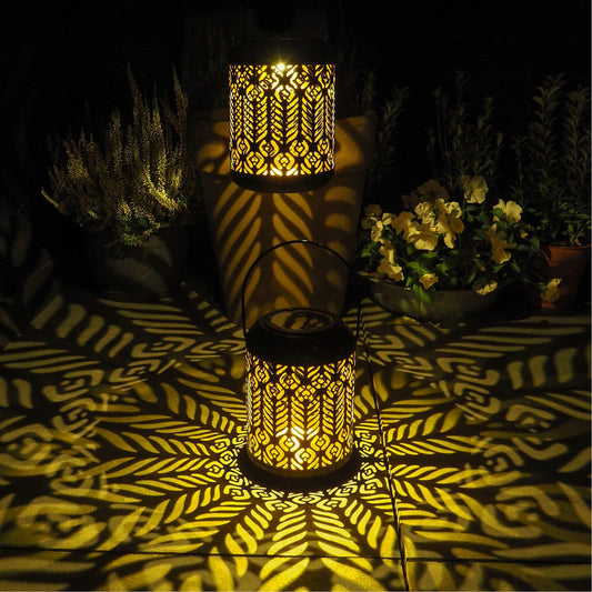 Decorative lantern casting patterns on a dark surface with plants in the background