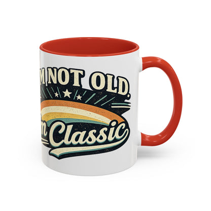 White mug with red interior and handle, featuring a retro design and text.