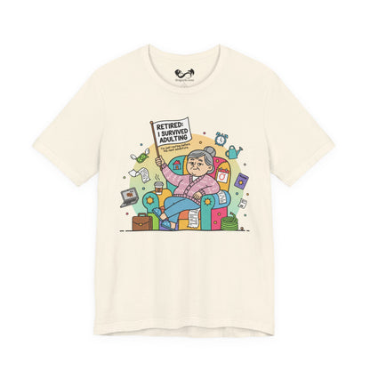 Beige t-shirt with a colorful graphic of a retired person holding a sign and sitting on a couch, on a white background.