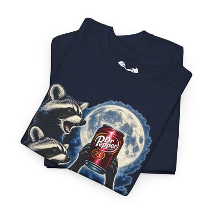 A navy blue folded t-shirt featuring a graphic print of two raccoons holding a red Dr. Pepper can in front of a full moon.