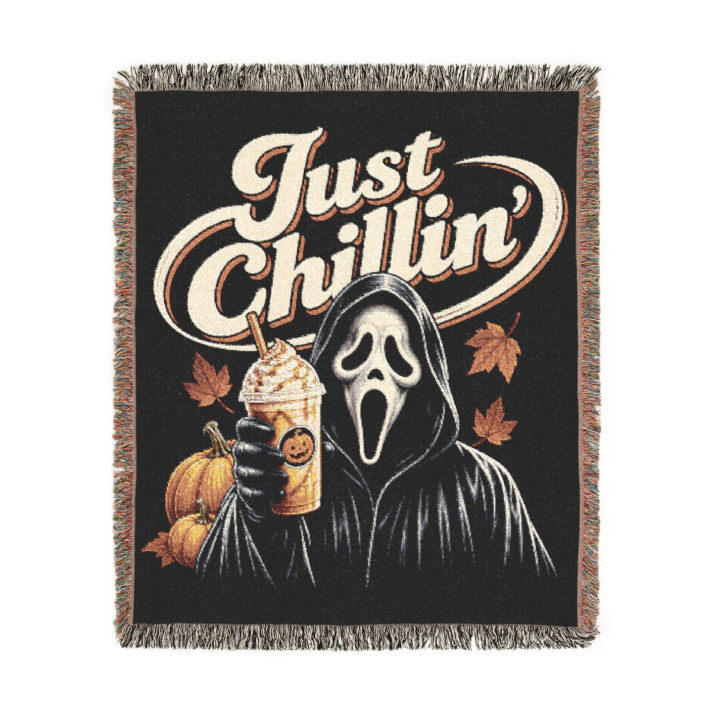 A woven throw blanket with fringe edges, featuring a black background and a graphic of a hooded ghost-face figure holding a drink, with pumpkins, autumn leaves, and the words “Just Chillin’” in large cream lettering.