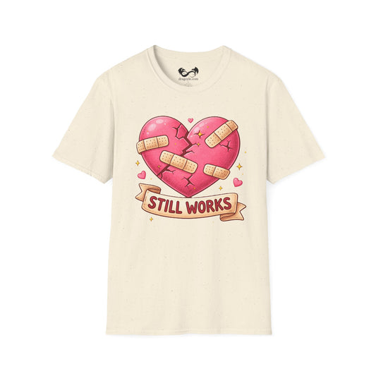 Beige t-shirt with a heart graphic and 'Still Works' text on a white background