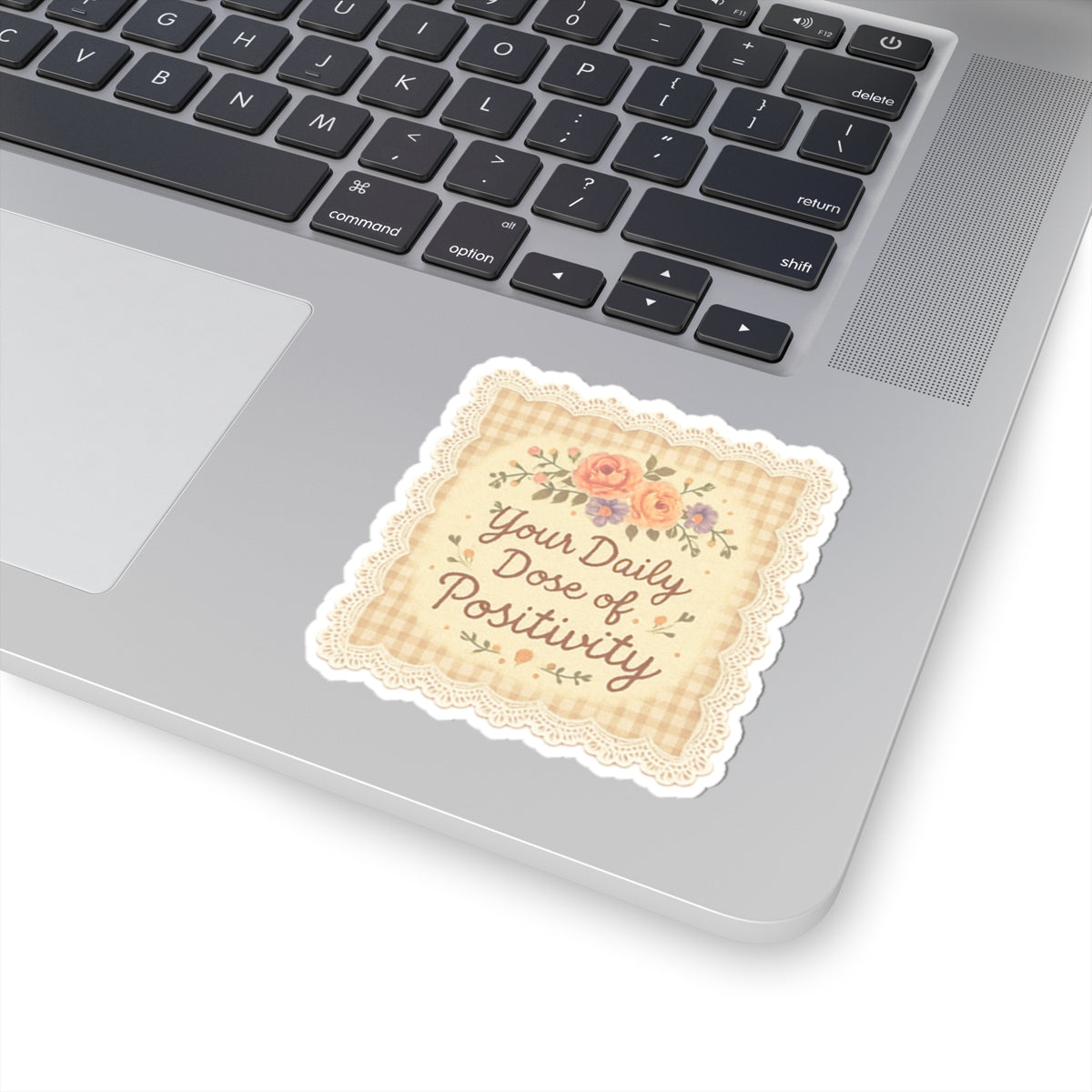 Decorative sticker with 'Your Daily Dose of Positivity' text on a laptop