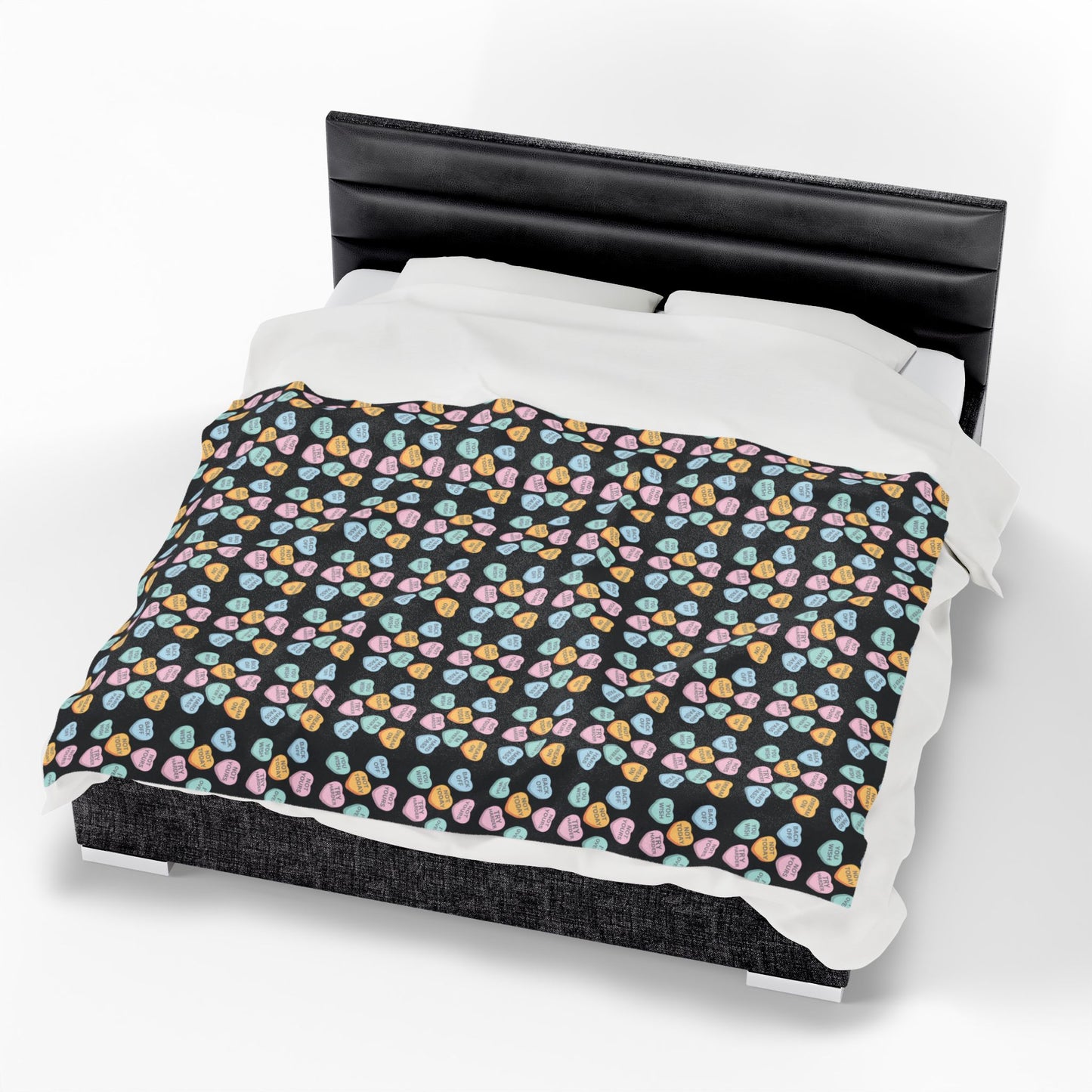 Bed with a black headboard and colorful patterned bedding on a white background
