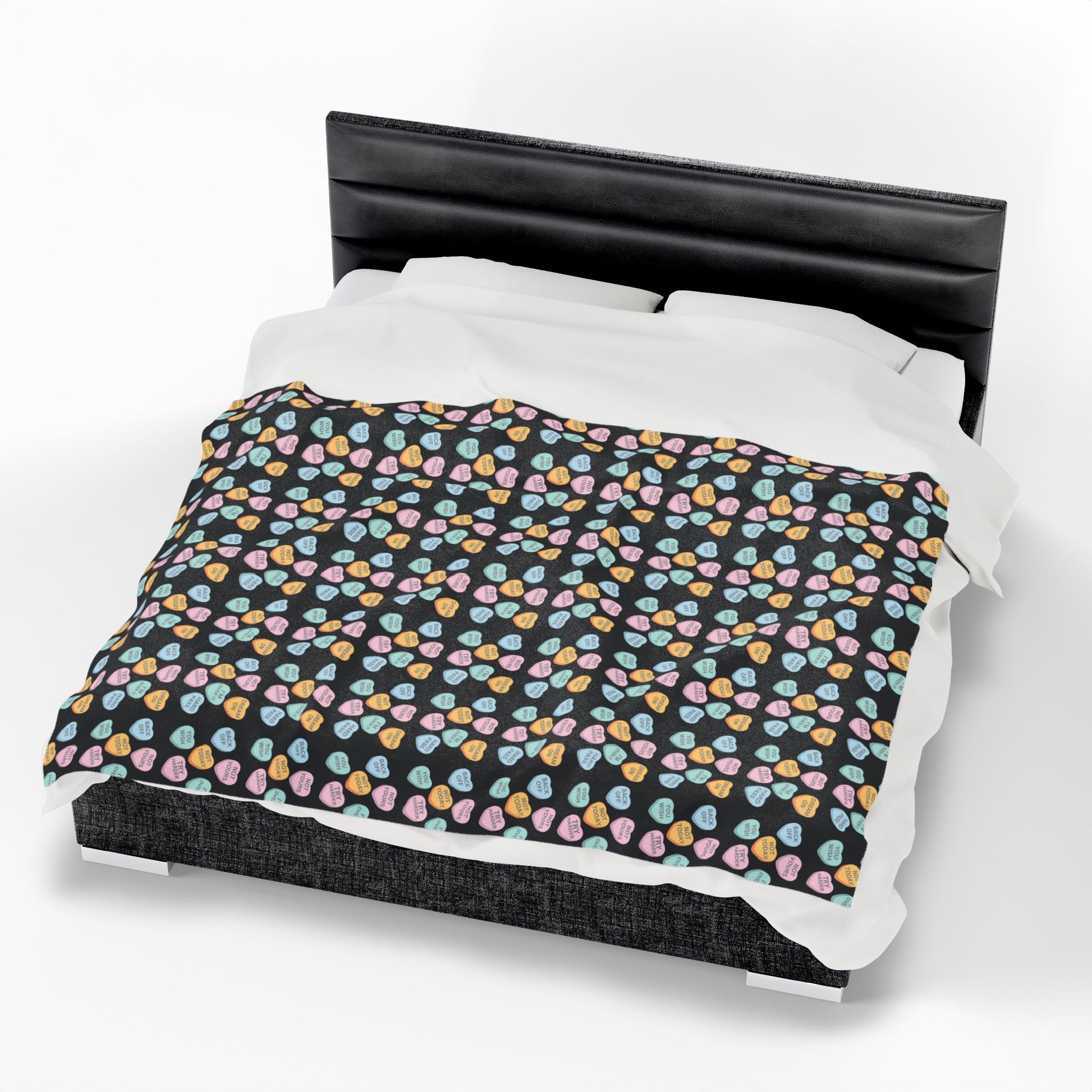 Bed with a black headboard and colorful patterned bedding on a white background