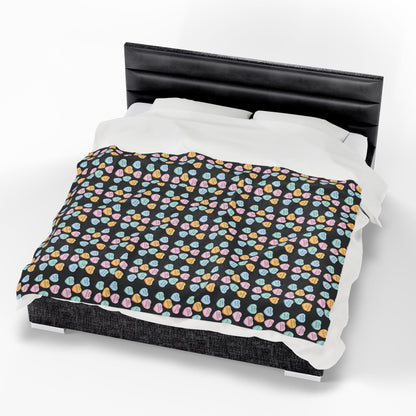 Bed with a black headboard and colorful patterned bedding on a white background