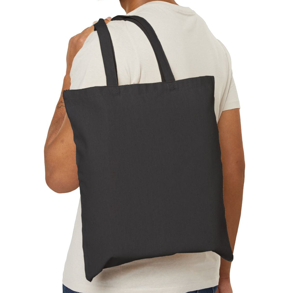 Man carrying a black tote bag on a white background