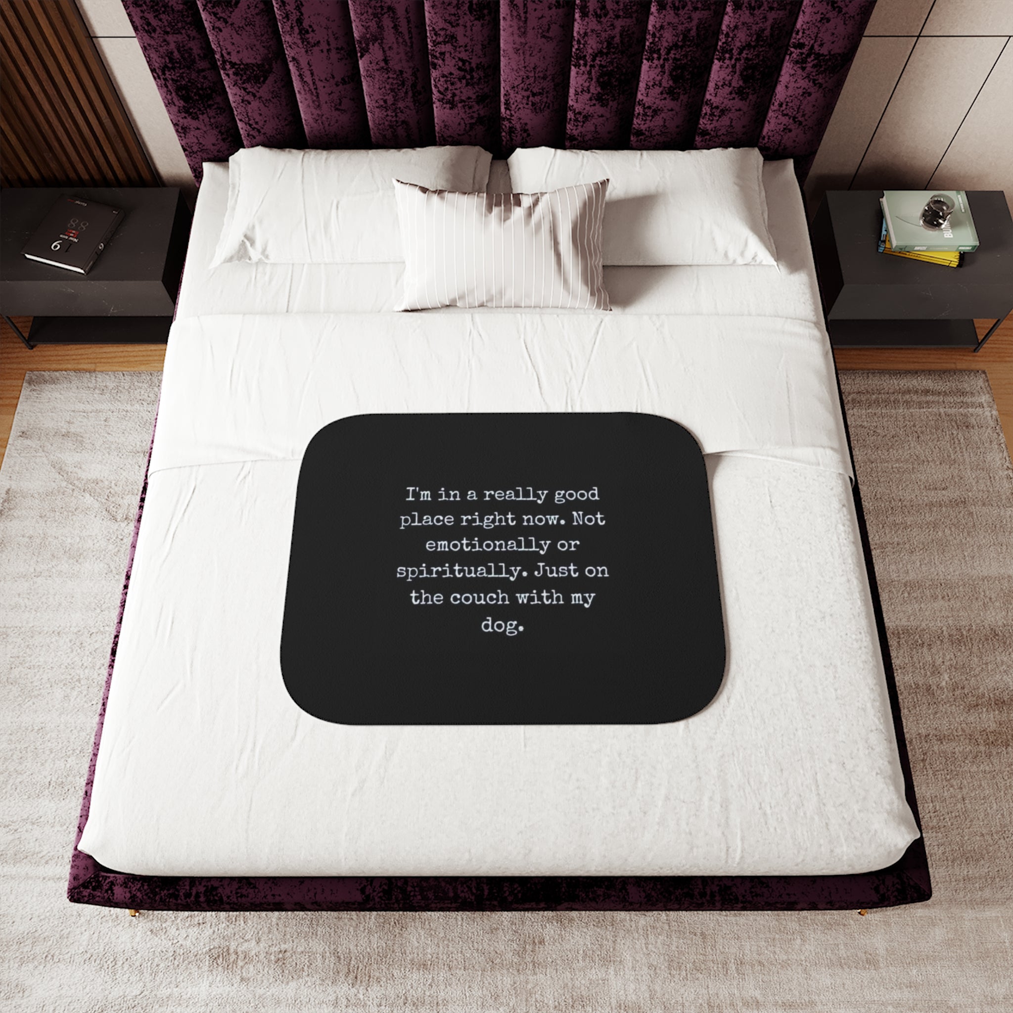 Black square mat with text on a bed in a bedroom setting