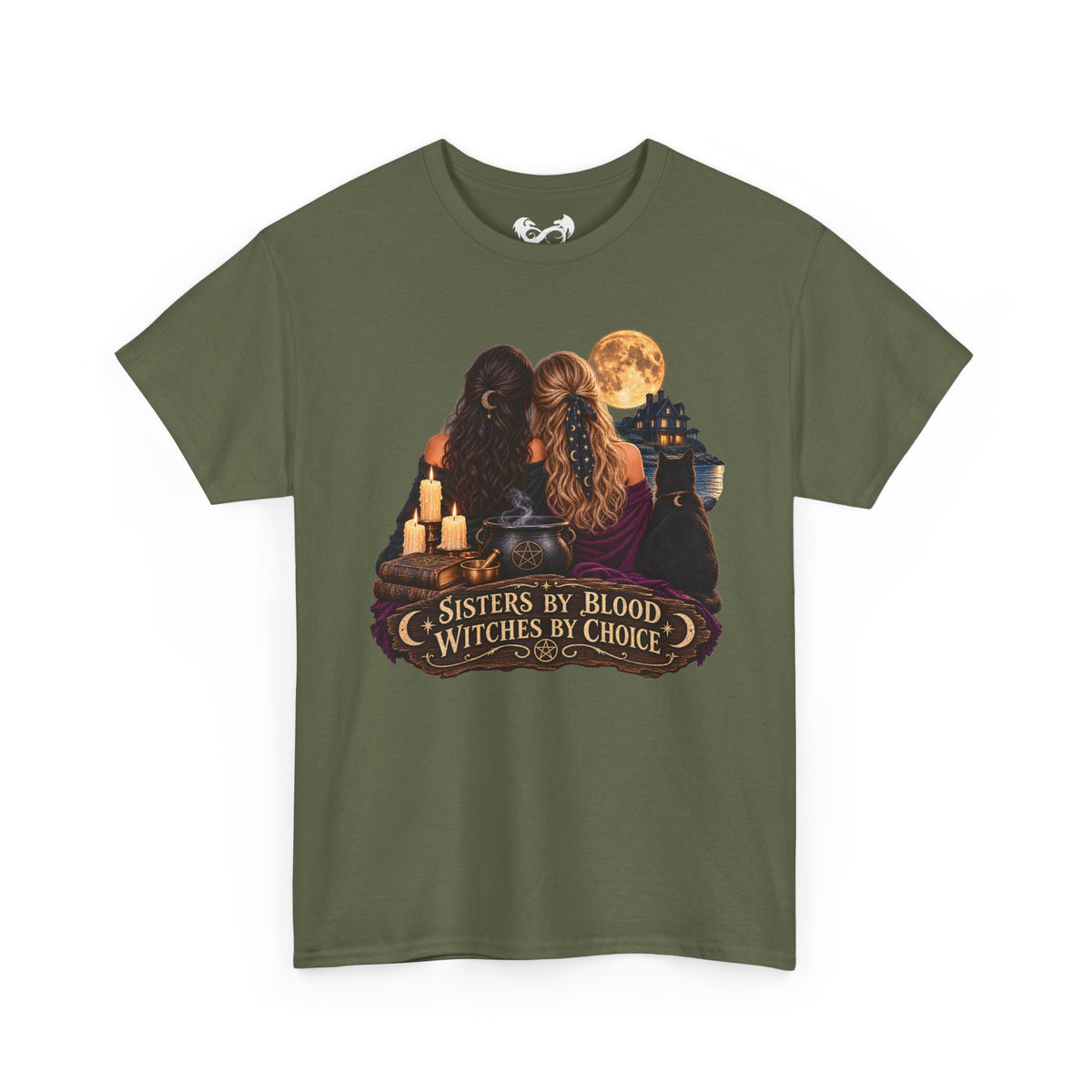 An olive green short-sleeve t-shirt with a graphic print of two witches sitting together under a full moon, featuring candles, a cauldron, and a banner that reads 'Sisters by Blood Witches by Choice'.