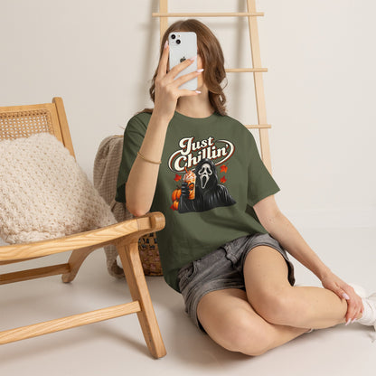 Person wearing a t-shirt with a 'Skeletor' design, sitting on the floor with a wooden chair and ladder in the background.